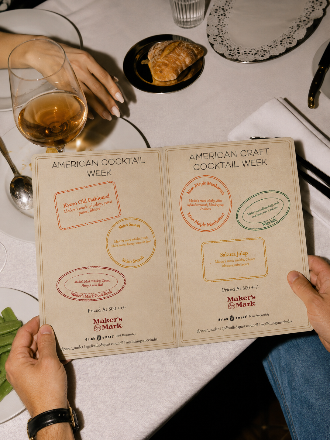 Guests holding the open American Cocktail Week menu spread at the table