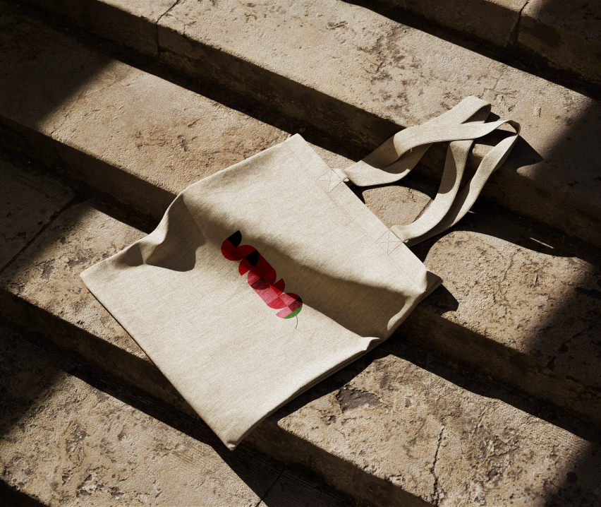 Canvas tote bag printed with the Spicey Guava mark on stone steps