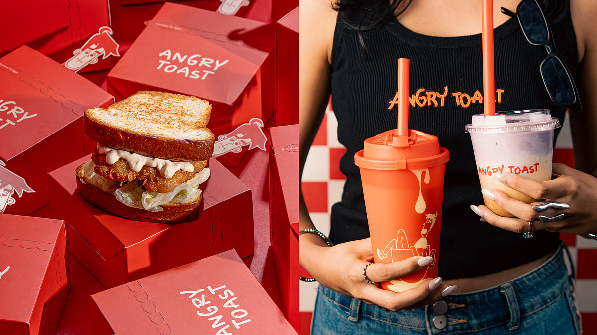 Fried sandwich on a pile of red boxes beside two branded cups