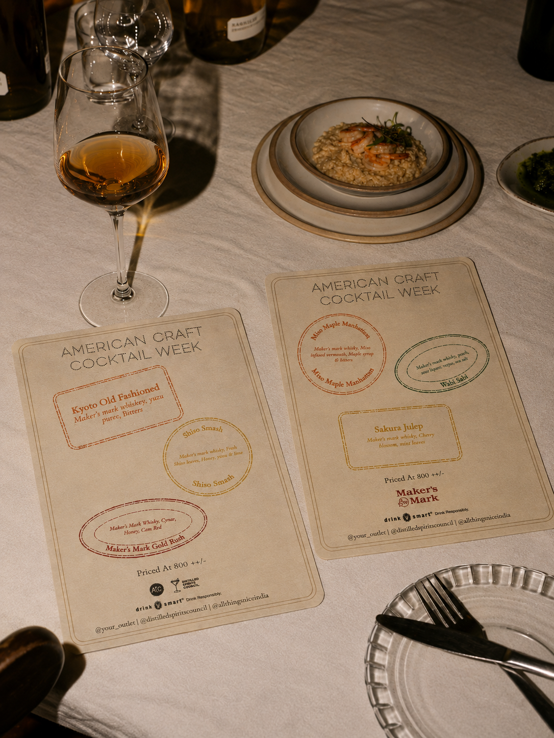 Two American Craft Cocktail Week menu cards on a dressed dinner table